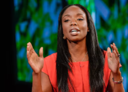 Nadine Burke Harris, uma mulher negra com cabelos longos lisos no palco do TEDMED 2014. A imagem é a capa do vídeo 